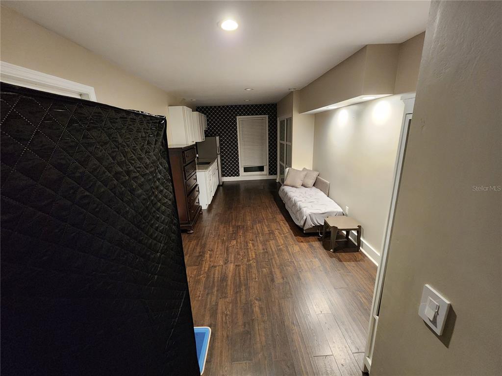 A long room features dark wood flooring, a daybed, and a kitchen area in the back — 149 SEA ISLE CIRCLE, SOUTH DAYTONA, FL