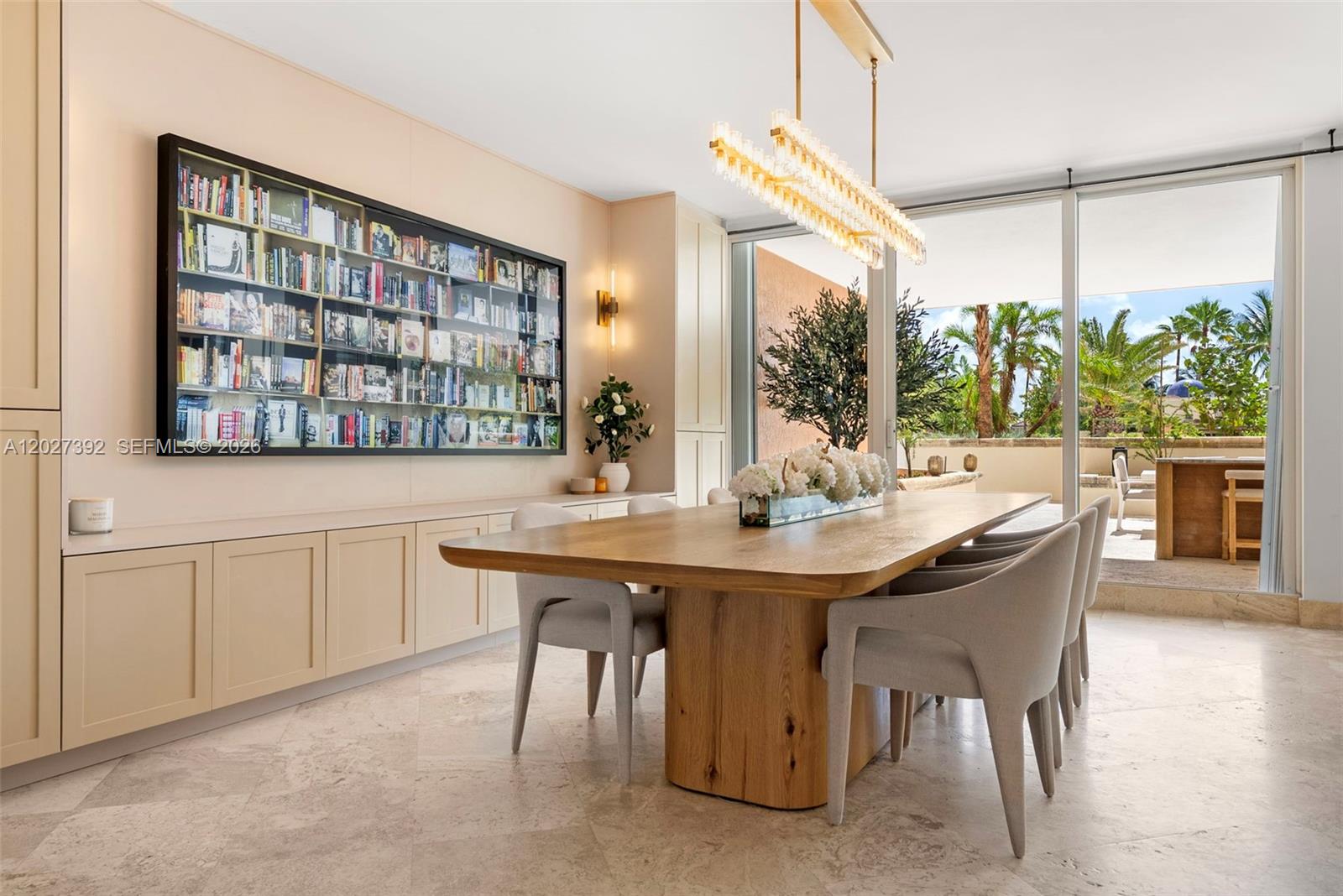 A dining room features a wooden table, upholstered chairs, a built-in bookshelf, and a terrace — 785 Crandon Blvd, Key Biscayne FL 33149, KEY BISCAYNE, FL