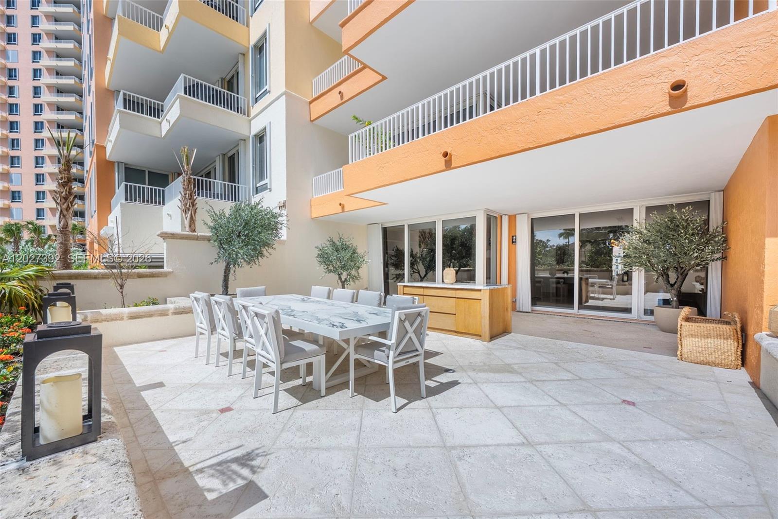 A spacious outdoor patio features a marble dining table, white chairs, and potted trees — 785 Crandon Blvd, Key Biscayne FL 33149, KEY BISCAYNE, FL