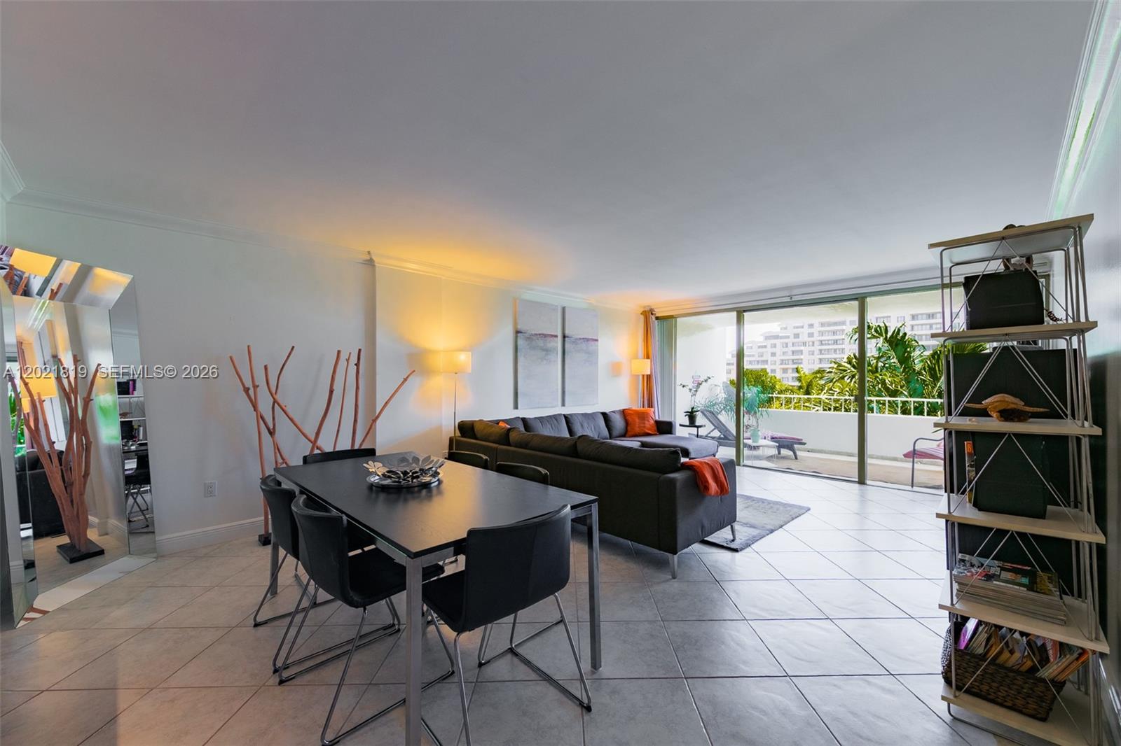 A living and dining area features tile floors, a dark sectional sofa, and a balcony — 199 Ocean Lane Dr # 413, Key Biscayne FL 33149, KEY BISCAYNE, FL