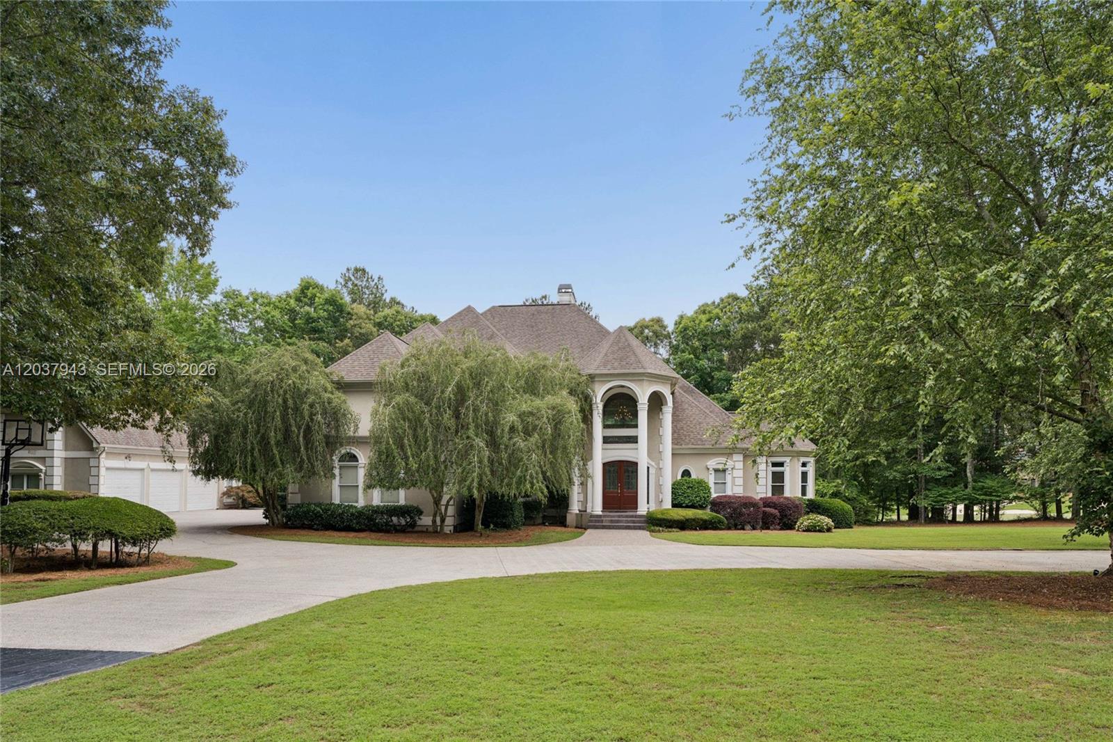 A large two-story house with a circular driveway and a prominent arched entryway — 1845 Kathy Whitworth Drive, GA 30517, GA