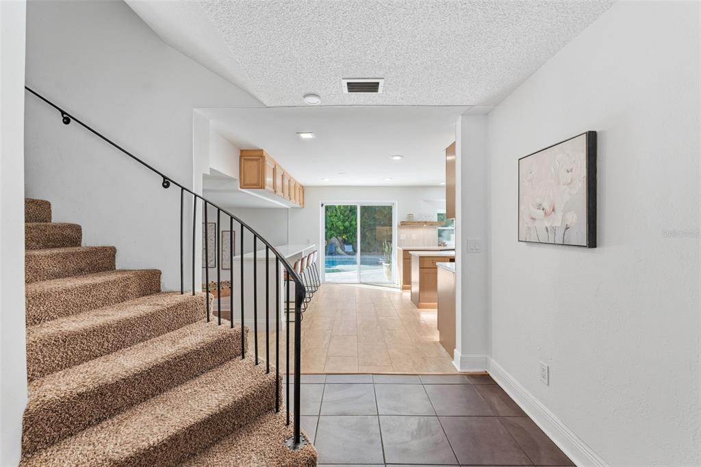A backyard features a swimming pool, a putting green, and a multi-level beige house — 1584 OAK LANE, CLEARWATER, FL