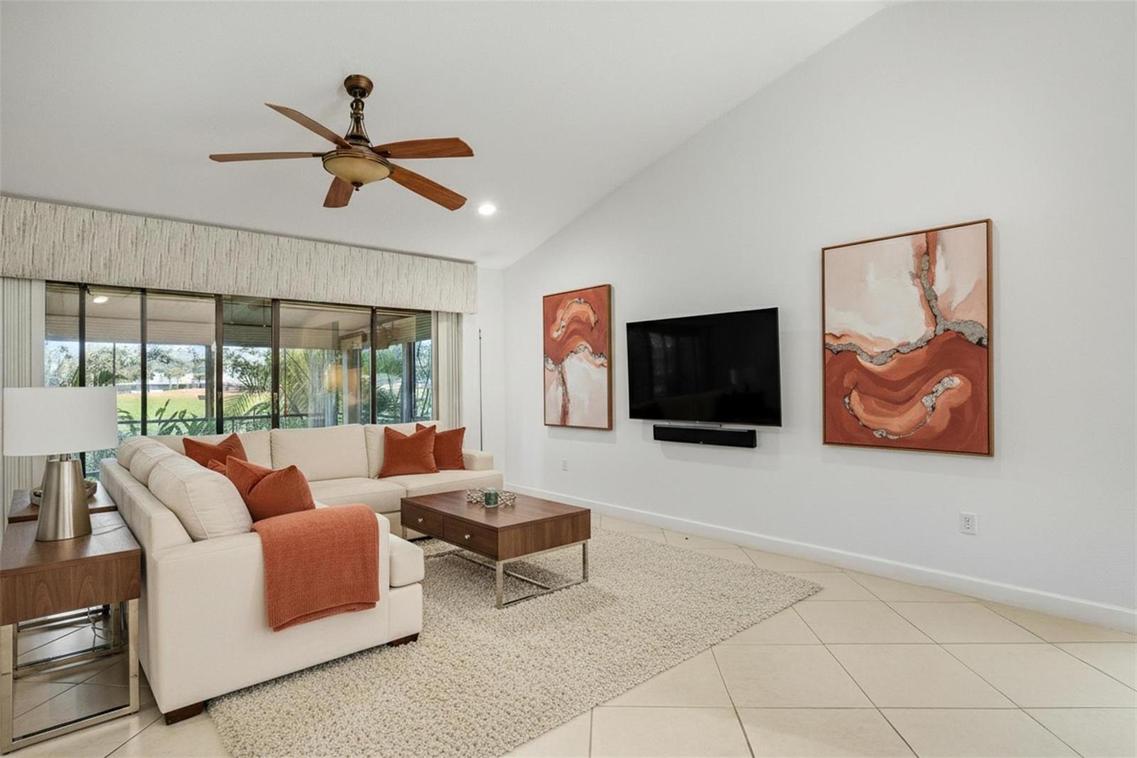 A living room features a white sectional sofa, a wooden coffee table, and wall-mounted art — 16131 Laurel Drive # 33, Weston FL 33326, WESTON, FL