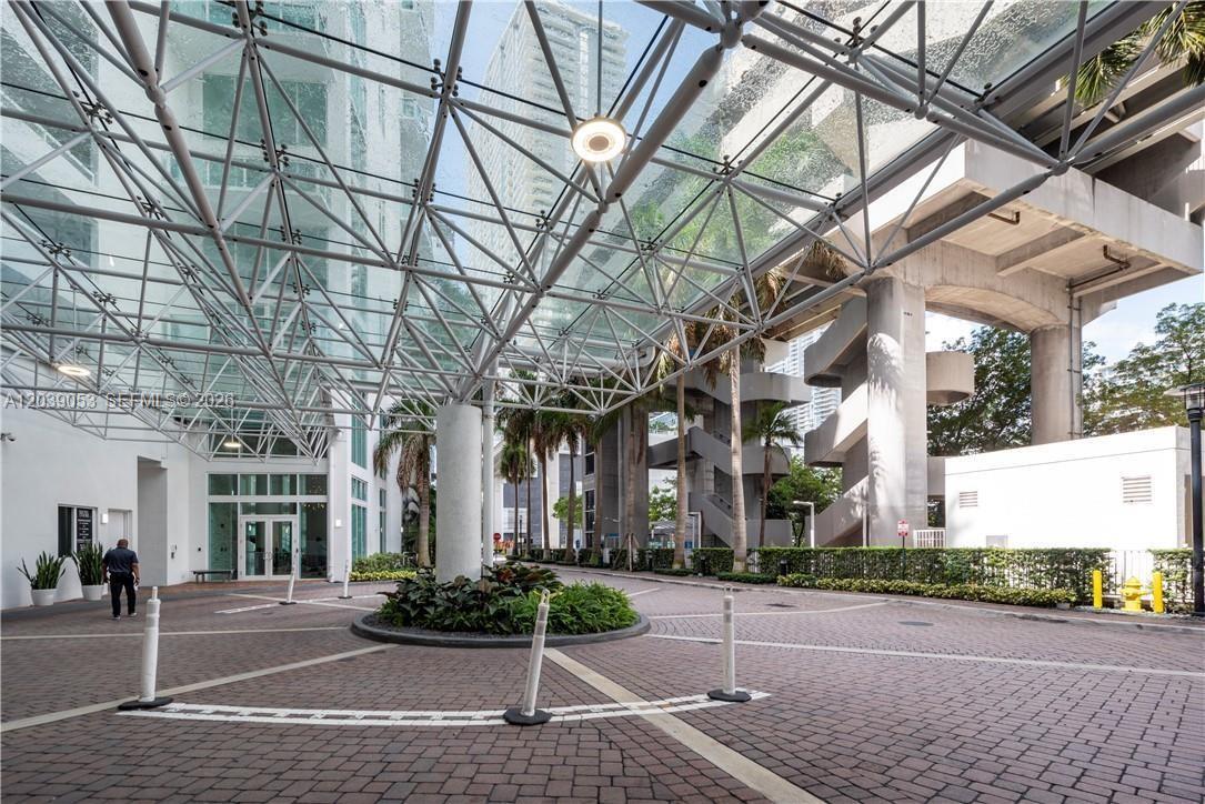A paved driveway leads to a building entrance covered by a large glass canopy structure — 31 SE 5th St # 705, Miami FL 33131, MIAMI, FL