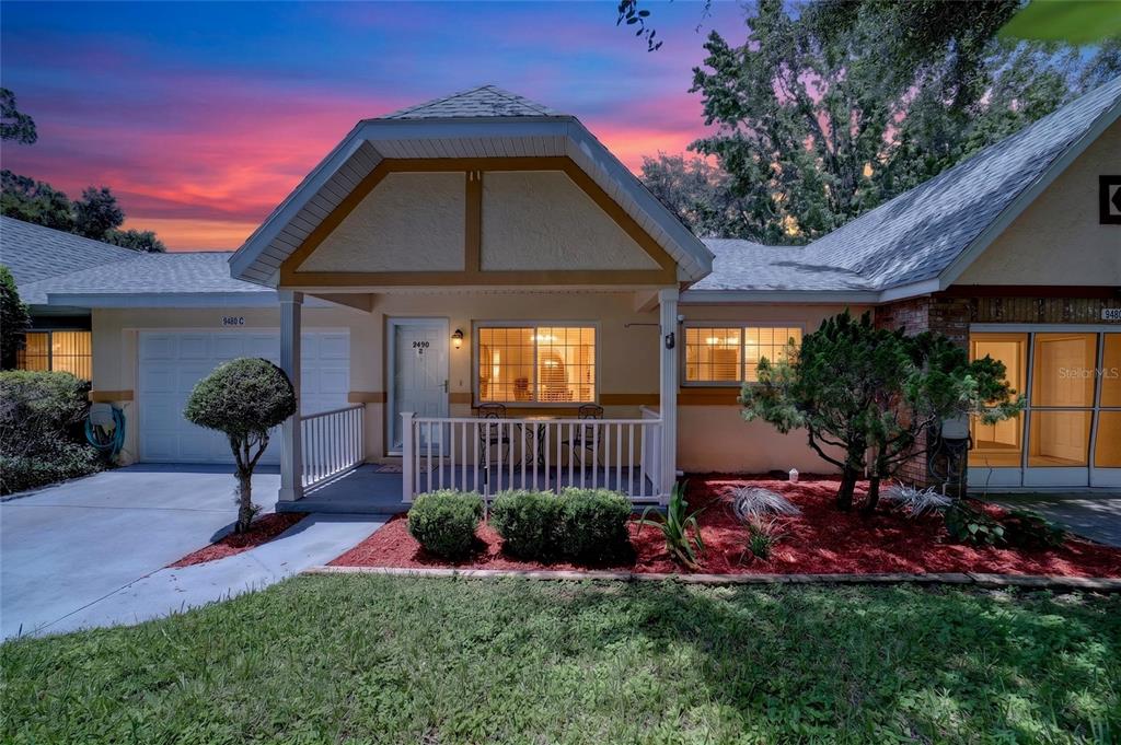 A single-story residential building exterior features a covered front porch, garage, and landscaped yard — 9490 SW 85TH AVENUE UNIT C, OCALA, FL