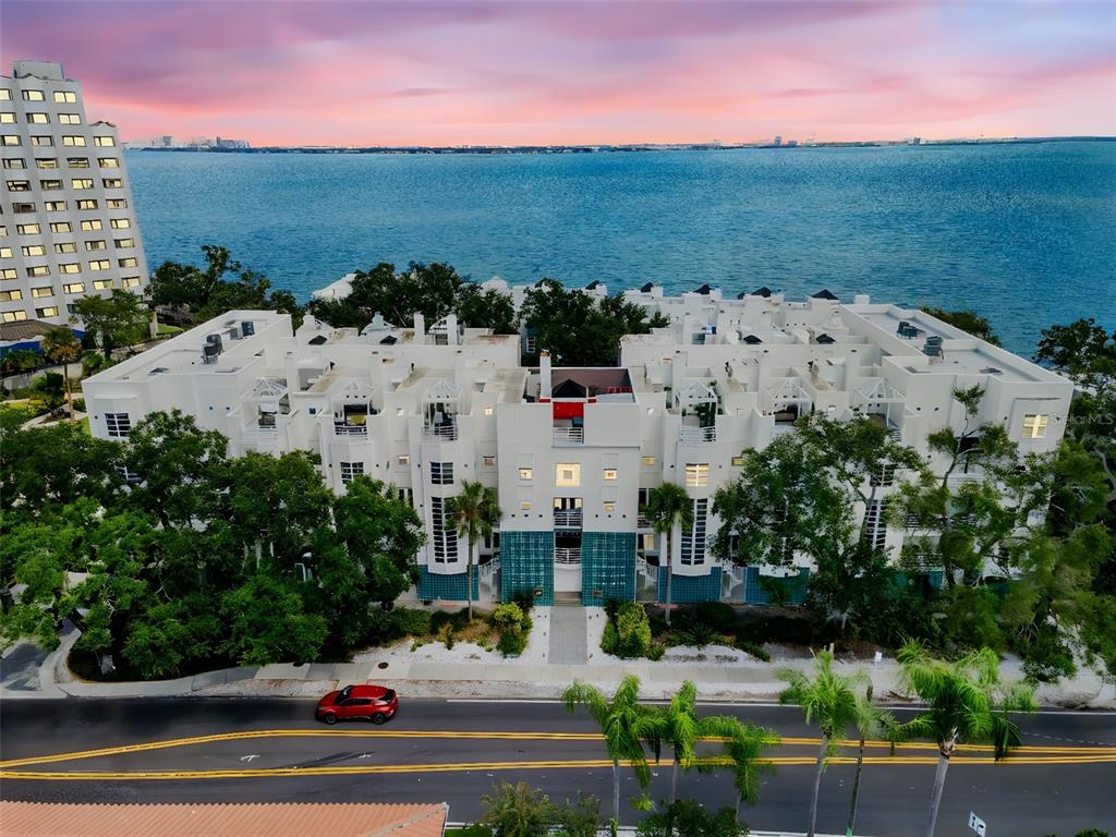 An aerial view of a white multi-story apartment complex situated along a waterfront — 4950 BAYSHORE BOULEVARD UNIT 23, TAMPA, FL