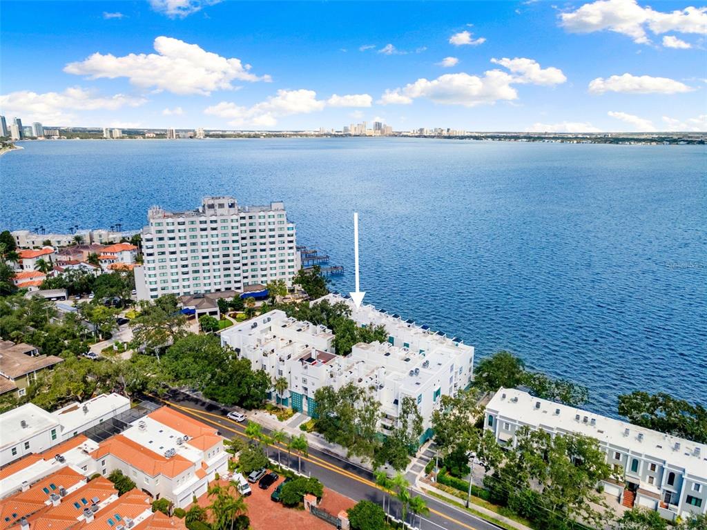 An aerial view shows a white multi-story residential complex situated along a large body of water — 4950 BAYSHORE BOULEVARD UNIT 23, TAMPA, FL