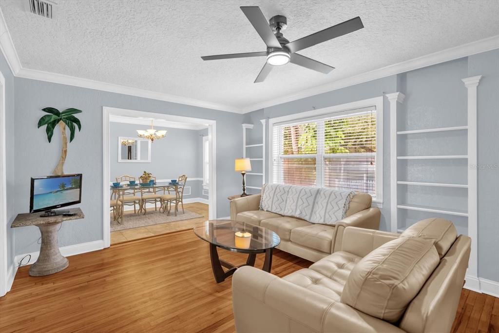 A living room with light blue walls, hardwood floors, a ceiling fan, and leather furniture — 918 W SMITH STREET, ORLANDO, FL