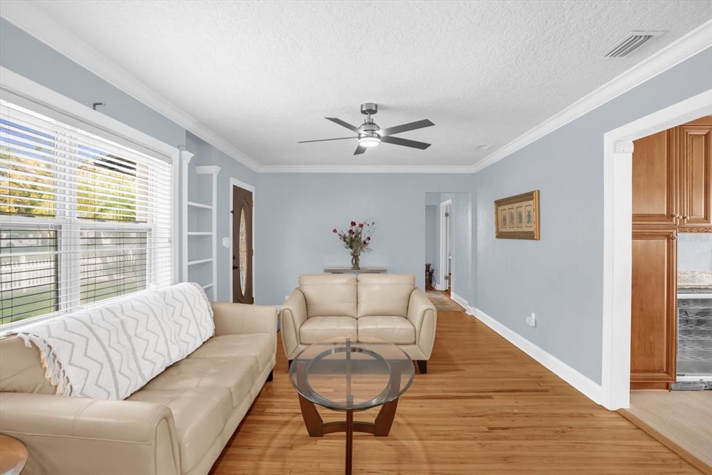 A living room features light blue walls, hardwood floors, two beige sofas, and a ceiling fan — 918 W SMITH STREET, ORLANDO, FL