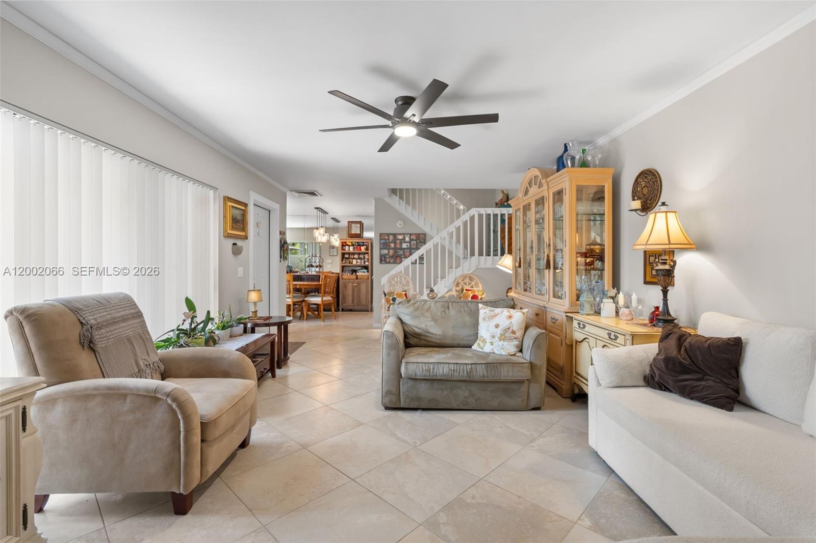 A living room features tile flooring, a ceiling fan, a staircase, and neutral-toned furniture — 7124 71st Way, West Palm Beach FL 33407, WEST PALM BEACH, FL
