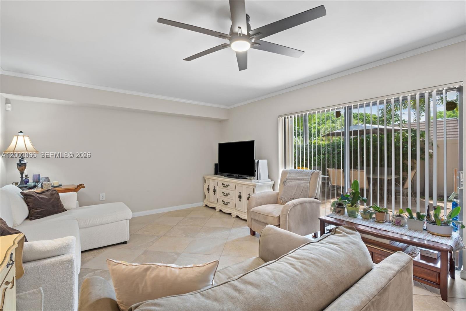 A living room features tile flooring, a ceiling fan, a television console, and sliding glass doors — 7124 71st Way, West Palm Beach FL 33407, WEST PALM BEACH, FL