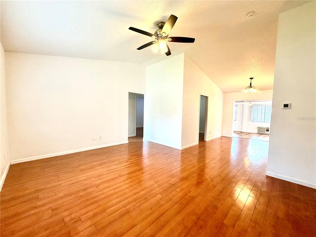 An empty room with hardwood floors, a ceiling fan, and white walls — 3349 SASSAFRAS COURT, ORLANDO, FL