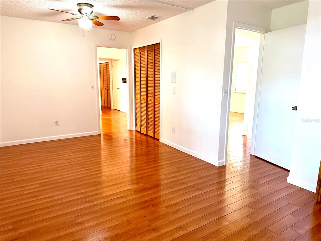 An interior room features hardwood flooring, a ceiling fan, and multiple doorways — 3349 SASSAFRAS COURT, ORLANDO, FL