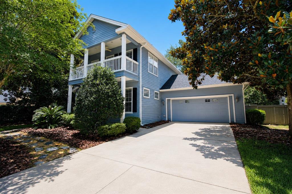 A two-story blue house with a front porch, balcony, and attached two-car garage — 9255 SW 29 AVENUE, GAINESVILLE, FL