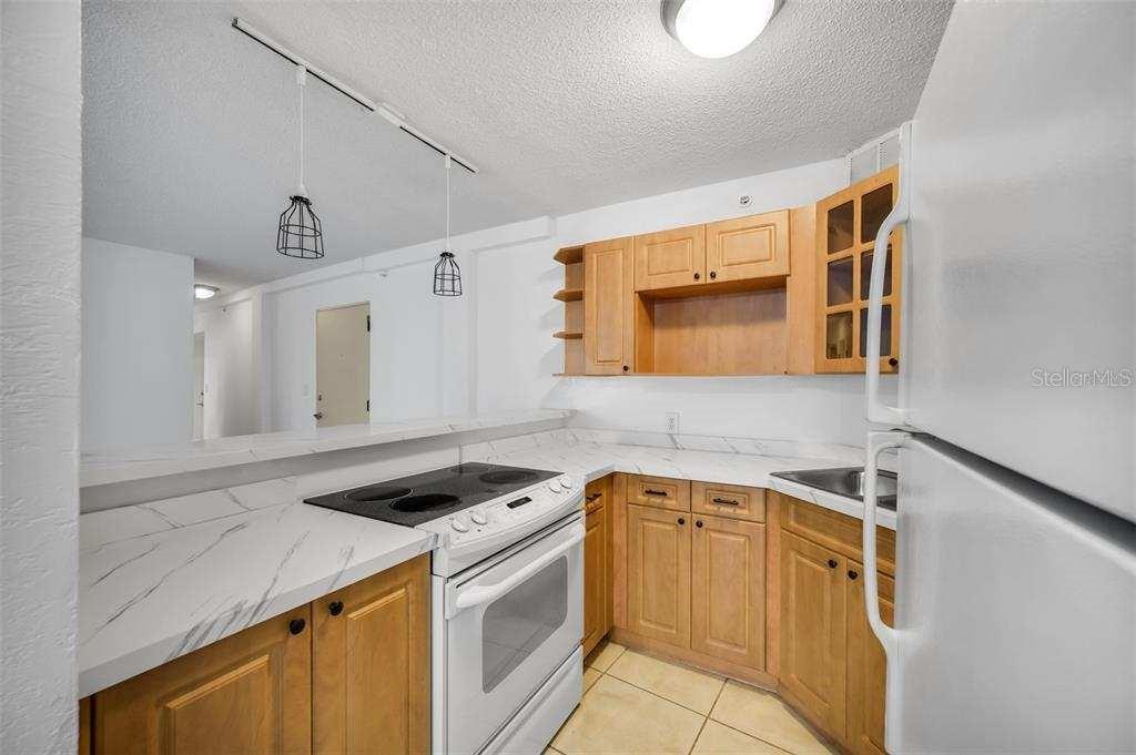 A kitchen with light wood cabinets, white marble-look countertops, and a white electric range — 3315 58TH AVENUE S UNIT 103, ST PETERSBURG, FL