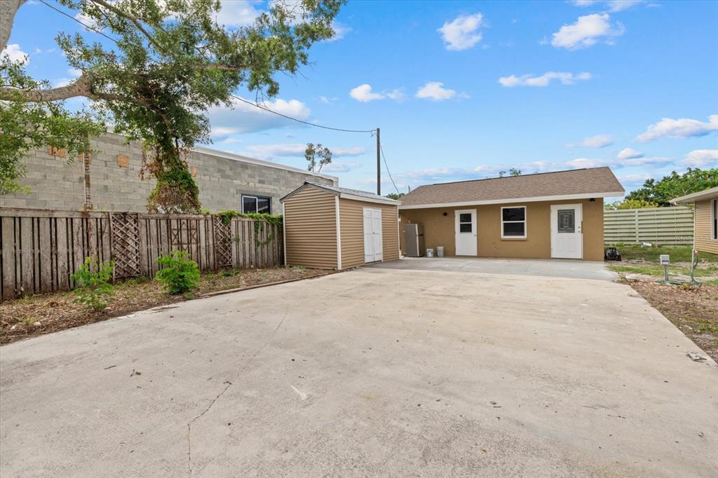 A concrete driveway leads to a detached garage and a small shed in a backyard — 2818 OLYMPIC STREET, SARASOTA, FL