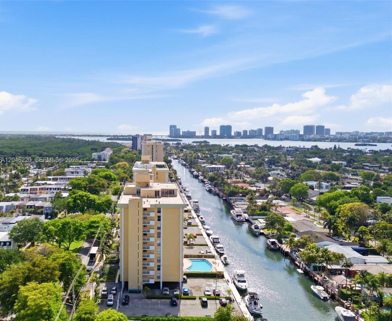 An aerial view shows a tall apartment building beside a canal lined with boats — NORTH MIAMI, FL