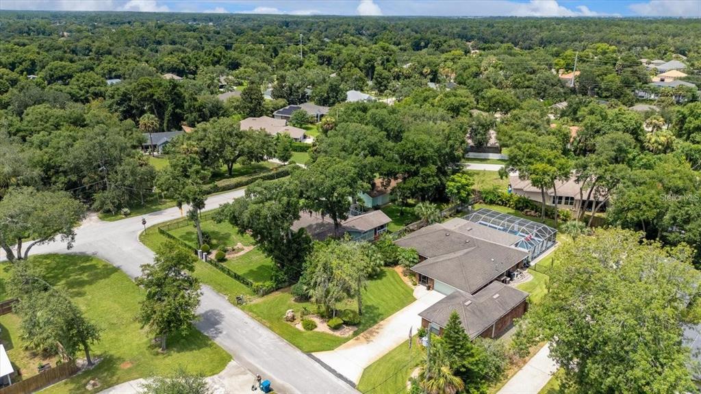 An aerial view shows a suburban house with a screened-in pool and a large yard — 1165 GEORGE ANDERSON STREET, ORMOND BEACH, FL