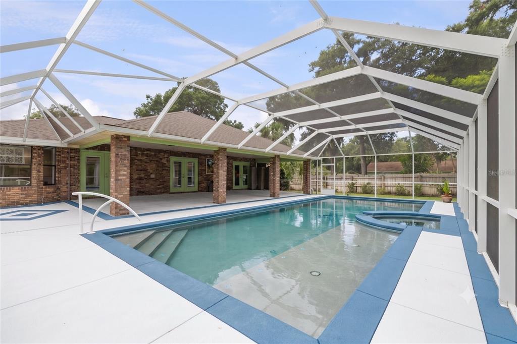 A screened-in patio features a swimming pool with an attached spa and brick pillars — 1165 GEORGE ANDERSON STREET, ORMOND BEACH, FL
