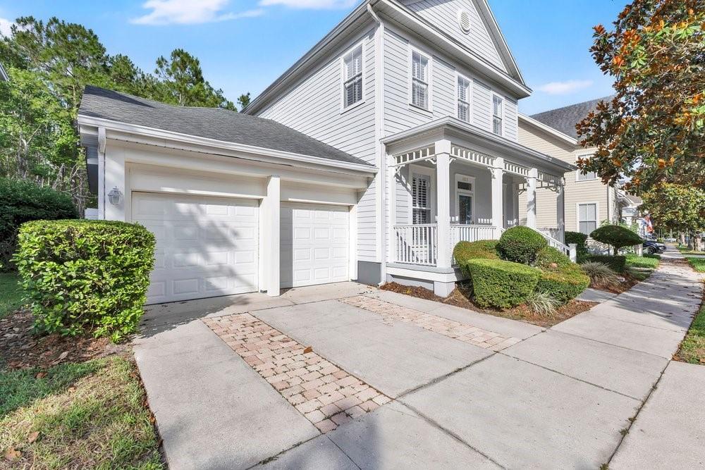 A two-story light gray house with a two-car garage and a front porch — 1013 MAIDEN TERRACE, CELEBRATION, FL