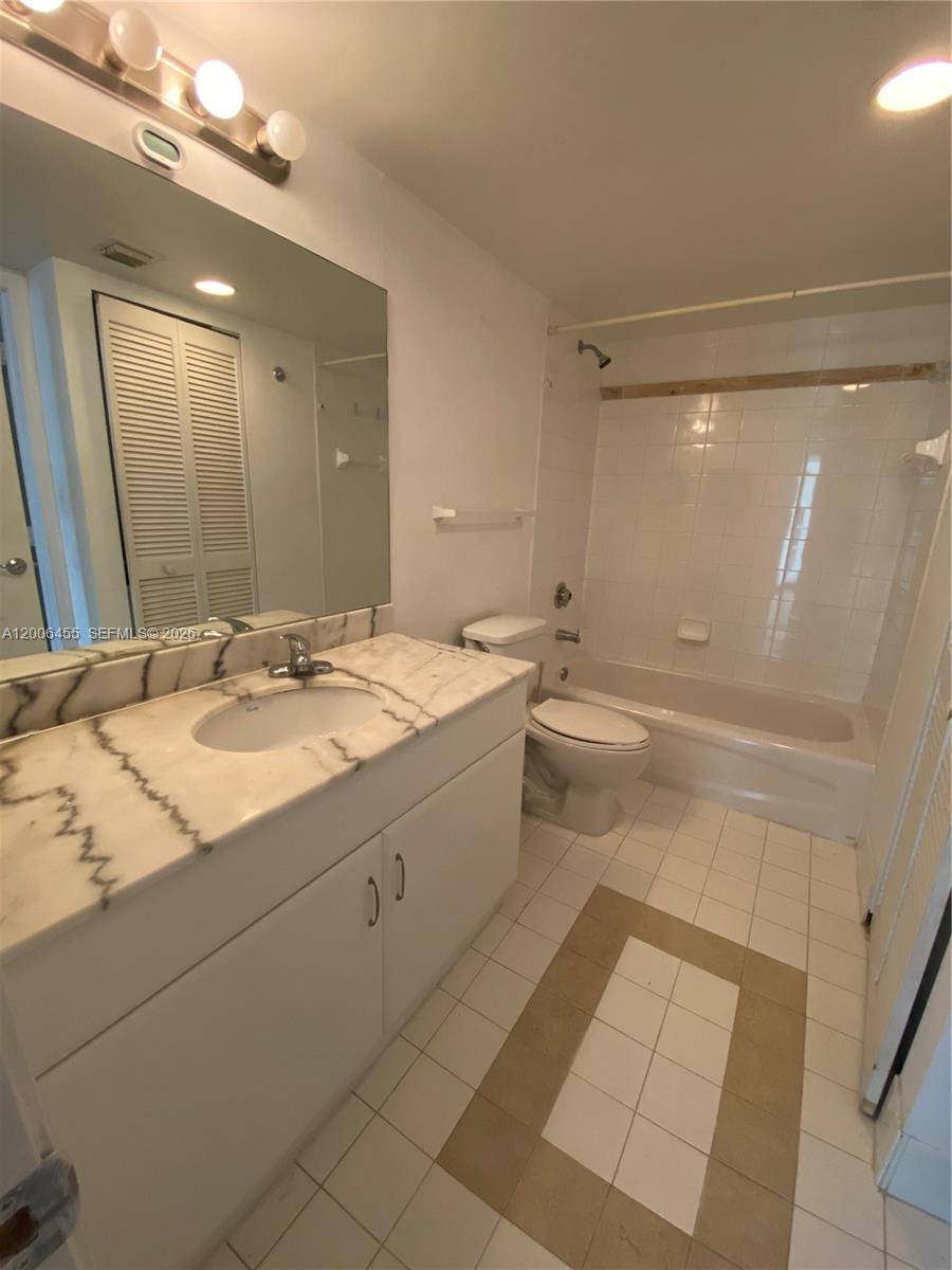 A bathroom features a marble-topped vanity, a toilet, and a tiled shower-tub combination — 1200 Brickell Bay Dr # 1914, Miami FL 33131, MIAMI, FL