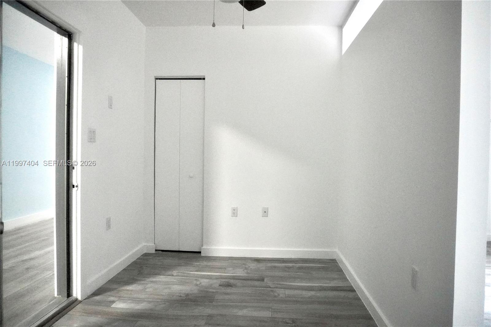 A small room with white walls, gray wood-look flooring, and a single closet door — 1036 SW 5th St # 12, Miami FL 33130, MIAMI, FL