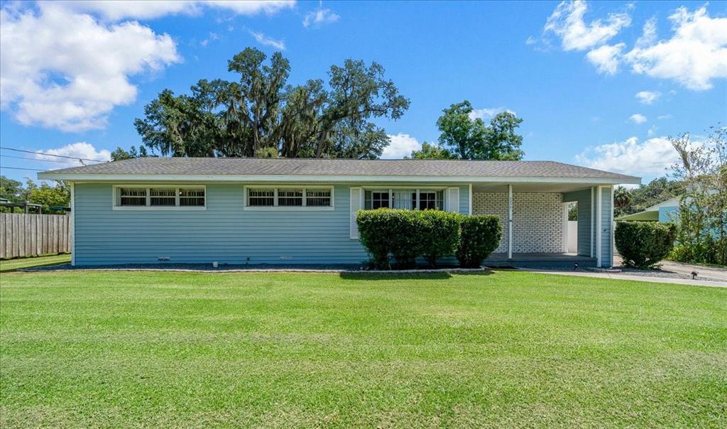 A single-story light blue house with a covered porch and a large front lawn — 2830 SE 6TH STREET, OCALA, FL
