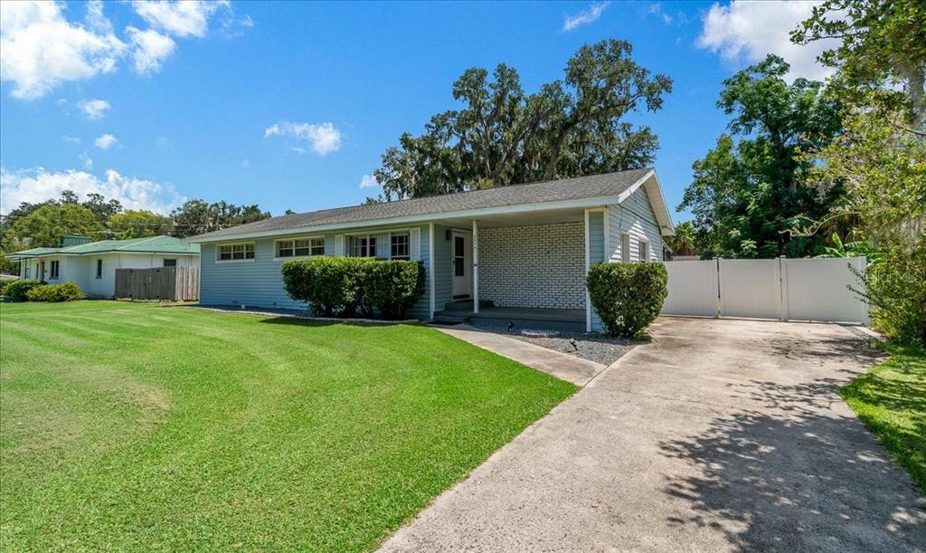 A light blue single-story house with a white brick porch and a concrete driveway — 2830 SE 6TH STREET, OCALA, FL