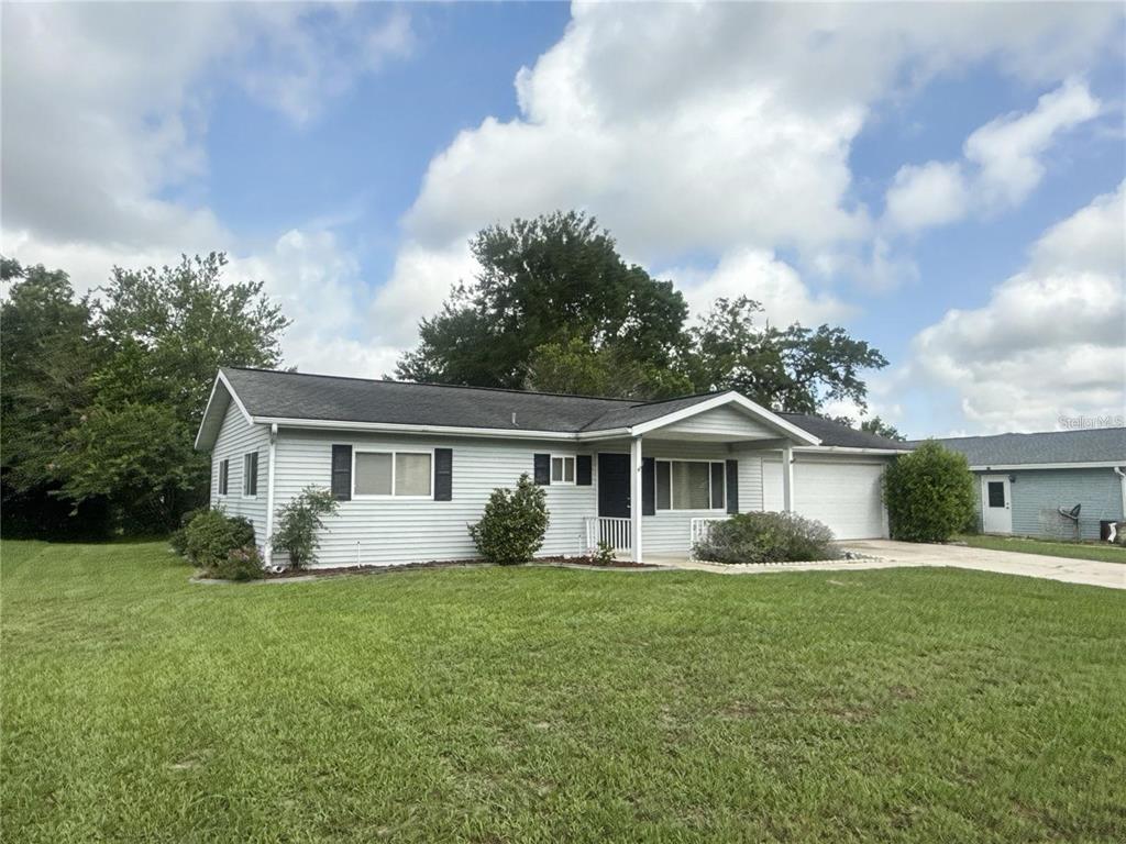 A single-story house with light gray siding, a dark roof, and an attached garage — 11248 SW 76TH TERRACE, OCALA, FL
