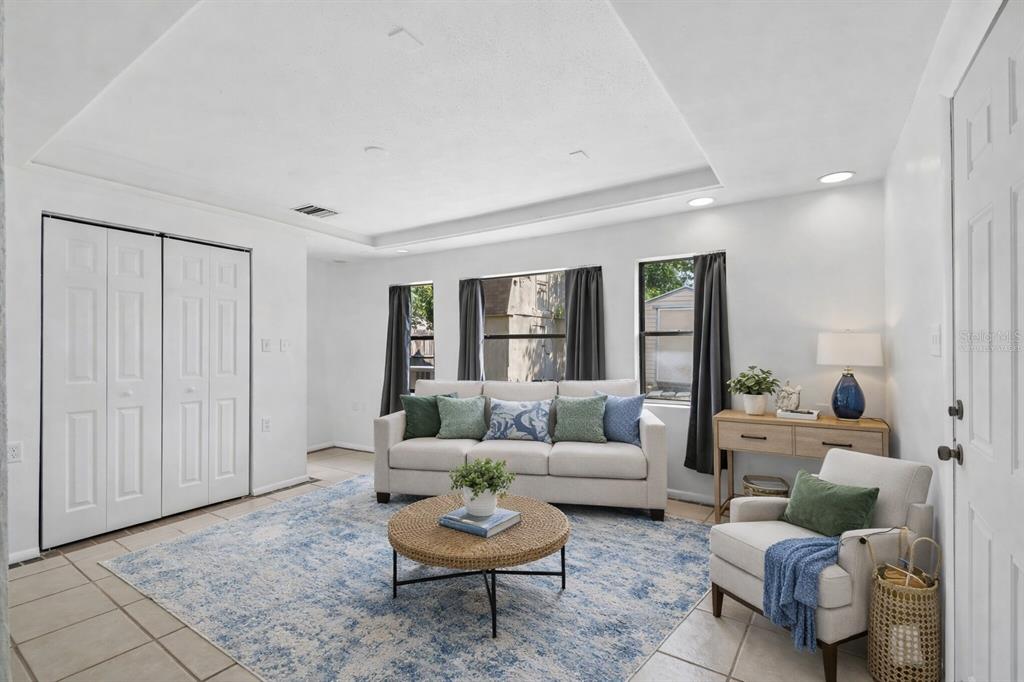 A living room features a light-colored sofa, a round coffee table, and a blue rug — 3640 MURROW STREET, NEW PORT RICHEY, FL