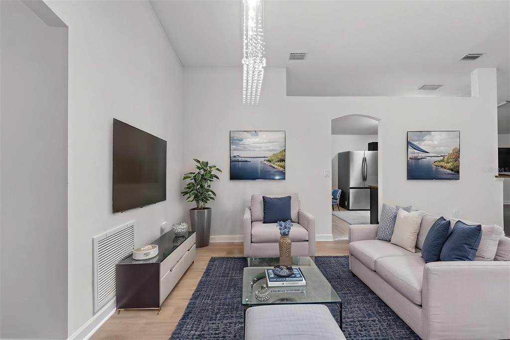 A living room features a wall-mounted television, a glass coffee table, and a blue rug — 1319 TARTON WAY, COCOA, FL