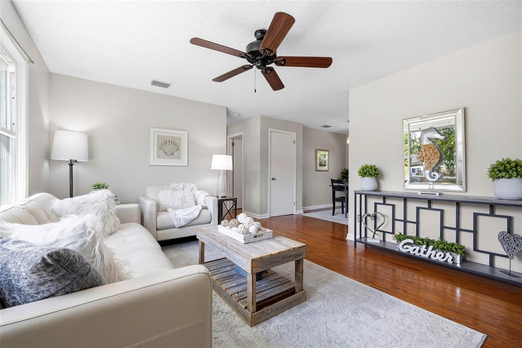 A living room features a white sofa, a wooden coffee table, and a console table — 1024 MICHIGAN DR E, DUNEDIN, FL