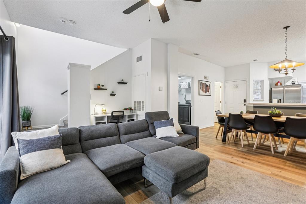 A living room with a gray sectional sofa, dining area, and a small built-in desk — 8419 CRYSTAL COVE LOOP, KISSIMMEE, FL