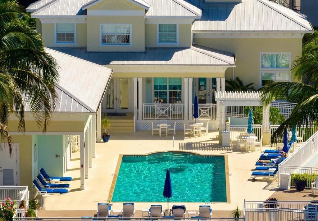 An exterior view of a house with a swimming pool, patio furniture, and palm trees — 7710 34TH AVENUE W UNIT 101, BRADENTON, FL