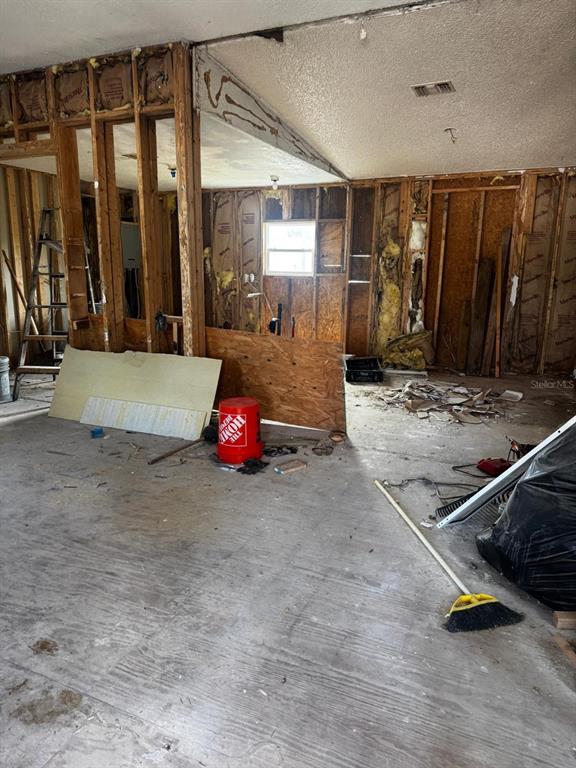 An interior room under construction with exposed wall studs, insulation, and a concrete floor — 2626 SHINER DRIVE, LAKE WALES, FL