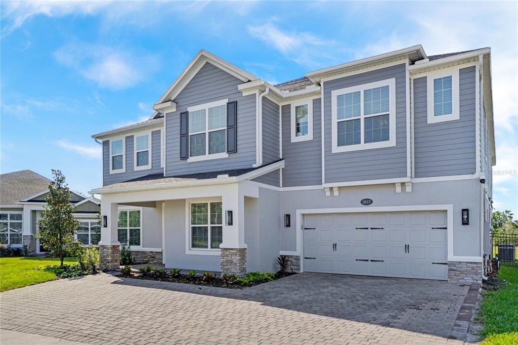 A two-story house with gray siding, a stone-accented porch, and a two-car garage — 2612 RAVENCLIFFE TERRACE, OVIEDO, FL