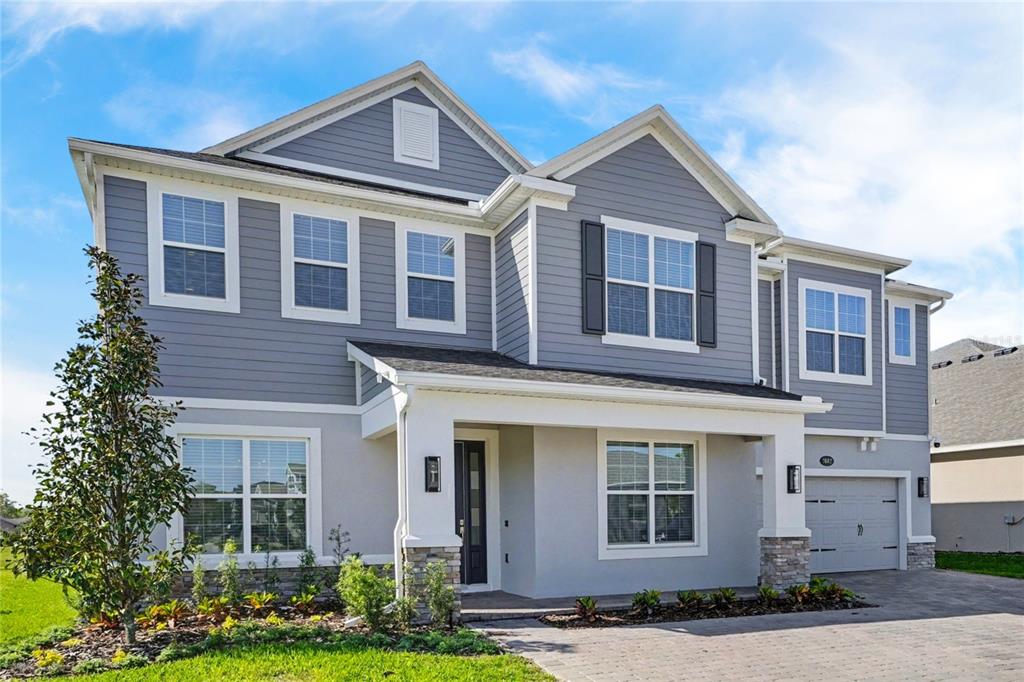 A two-story house with gray siding, a covered front porch, and an attached garage — 2612 RAVENCLIFFE TERRACE, OVIEDO, FL