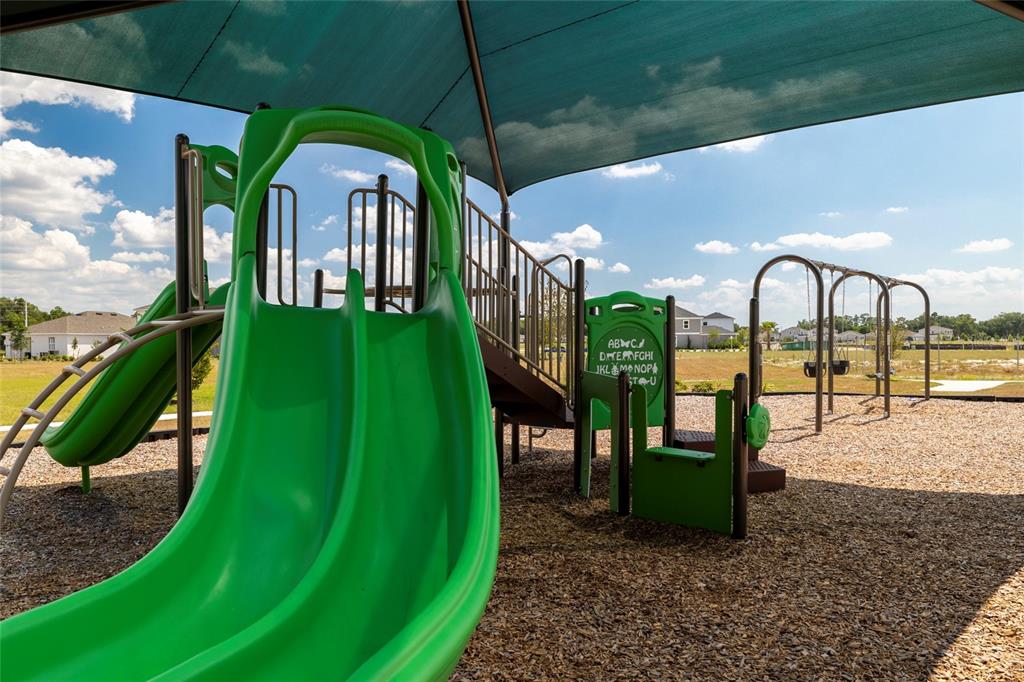 A playground features a green double slide, a small alphabet panel, and swings under a canopy — 6079 VISION ROAD, ST CLOUD, FL