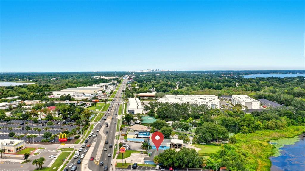 An aerial view shows a commercial property marked with a red pin near a highway — 8027 S ORANGE AVENUE, ORLANDO, FL