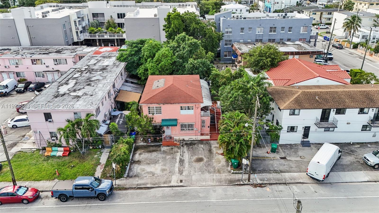 An aerial view shows a pink two-story house situated between two larger apartment buildings — 984 SW 6th St, Miami FL 33130, MIAMI, FL
