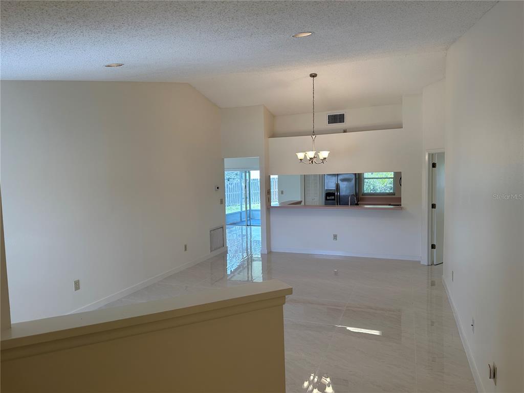 An open-concept living and dining area features white walls, tile flooring, and a breakfast bar — 5915 TAYWOOD DRIVE, TAMPA, FL
