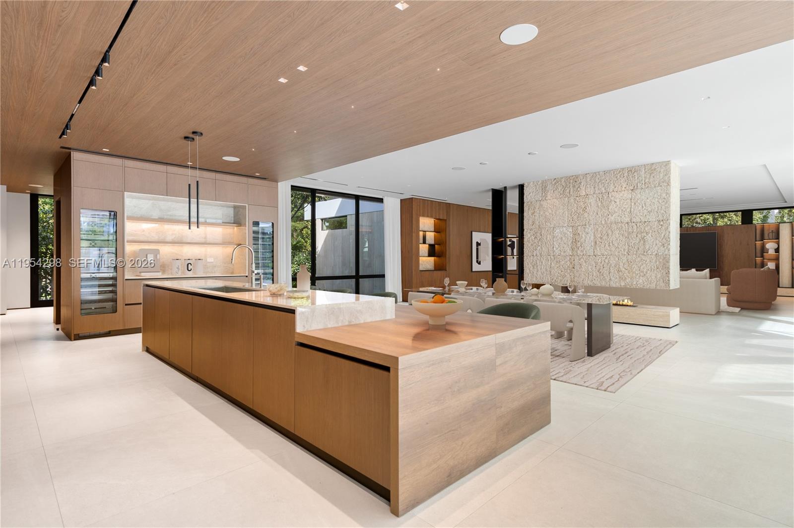 A modern kitchen features wood cabinetry, a large island, and an open-concept dining area — 3210 Coacoochee St, Miami FL 33133, MIAMI, FL