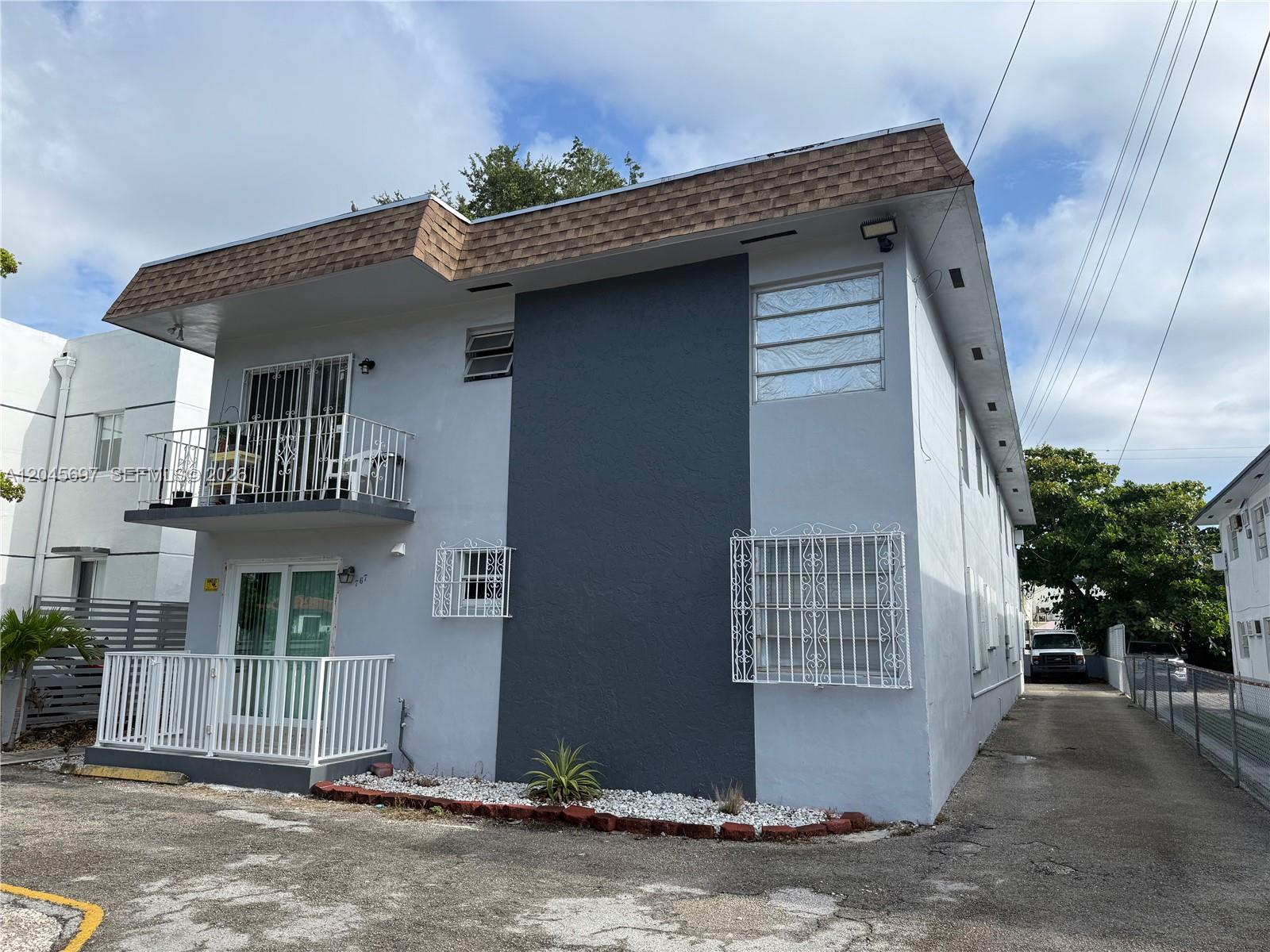 A two-story apartment building features a grey facade, a brown shingled roof, and security bars — 767 SW 9th St # 202, Miami FL 33130, MIAMI, FL