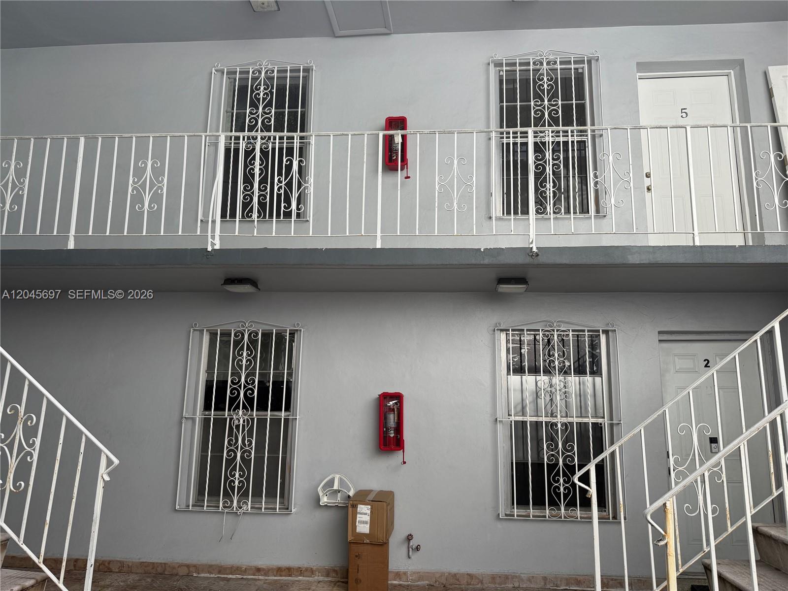 This exterior view shows a two-story apartment building with white metal railings and security bars — 767 SW 9th St # 202, Miami FL 33130, MIAMI, FL