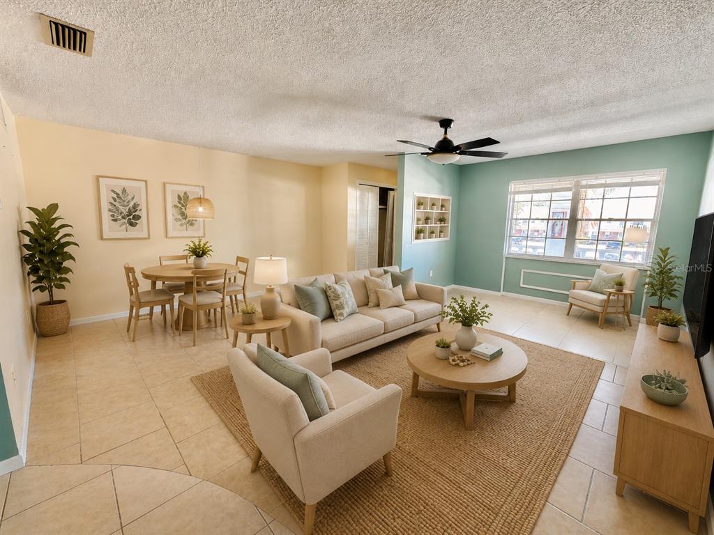 A living and dining room with beige tile floors, a beige sofa, and light blue walls — 4747 AZALEA DRIVE UNIT 229, NEW PORT RICHEY, FL