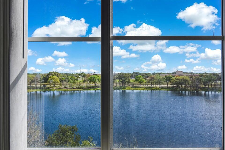 A view of a lake and trees seen through a large window — 1660 Renaissance Commons Boulevard # 2407, Boynton Beach FL 33426, BOYNTON BEACH, FL