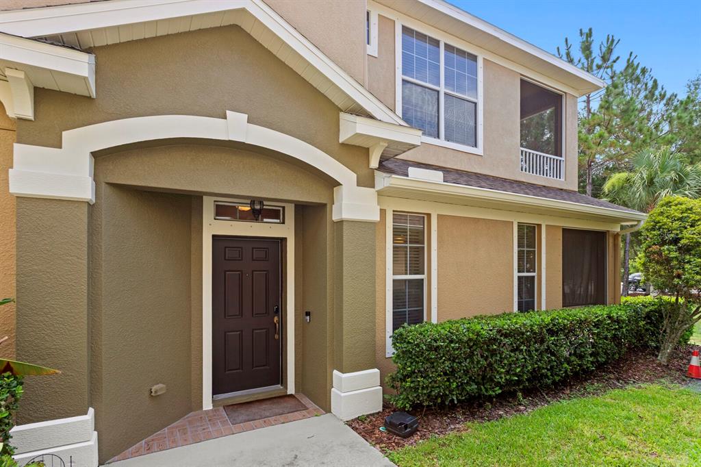 The exterior of a two-story house features a brown front door and a manicured hedge — 12639 SILVERDALE STREET, TAMPA, FL