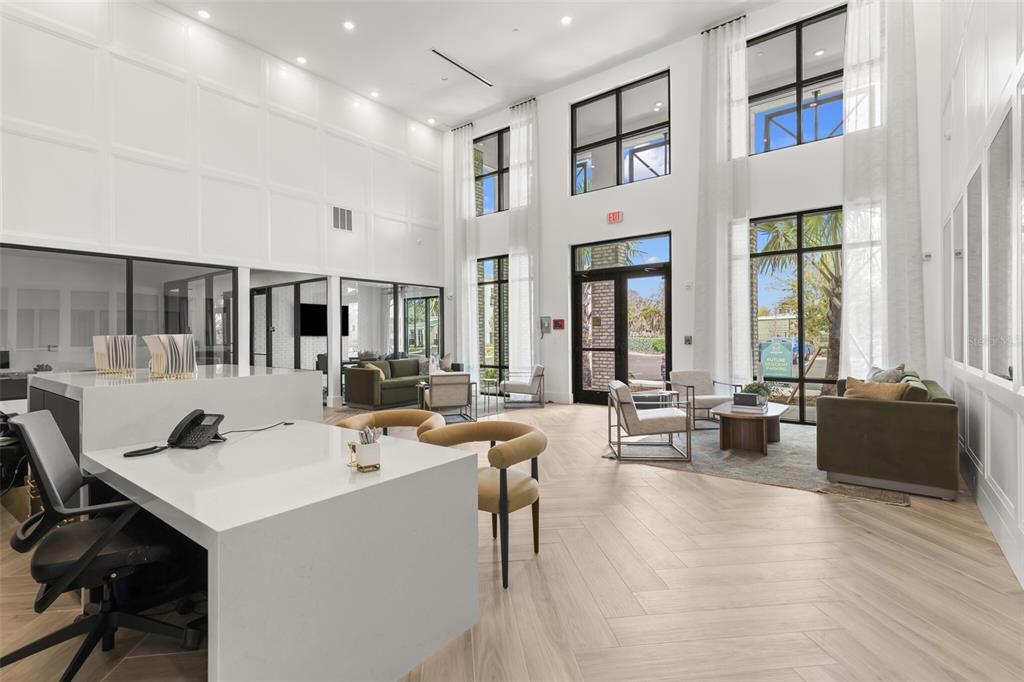 A modern, high-ceilinged office lobby with white paneled walls, light wood floors, and lounge seating — 7210 INTERBAY BOULEVARD UNIT C1, TAMPA, FL