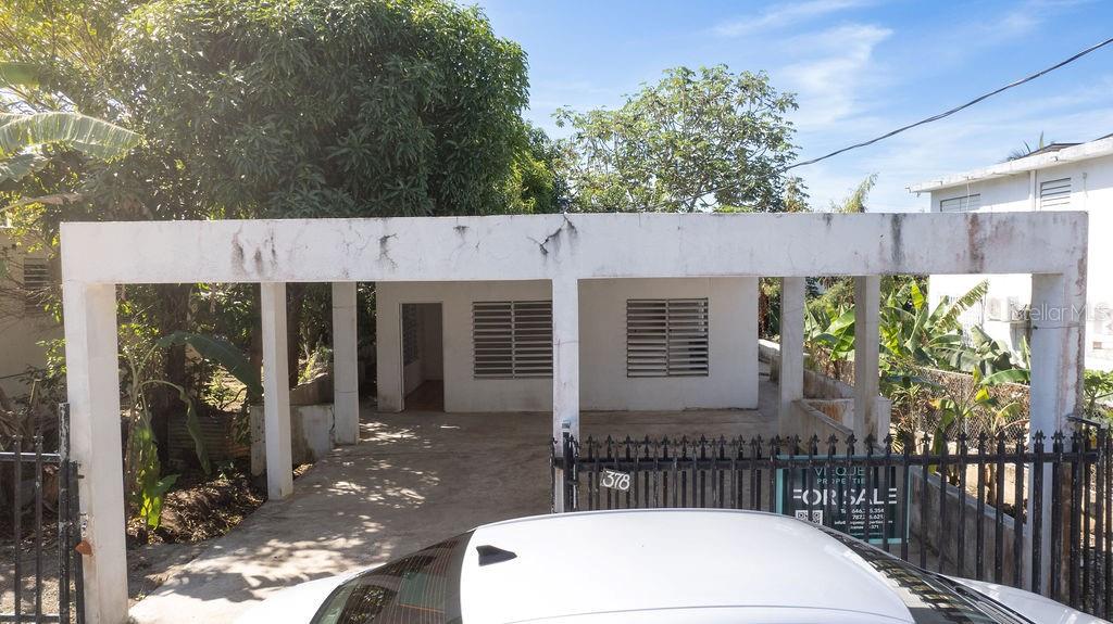 A white single-story house with a flat roof, carport, and metal security bars on windows — 378 CALLE GIRASOLES, VIEQUES, PR