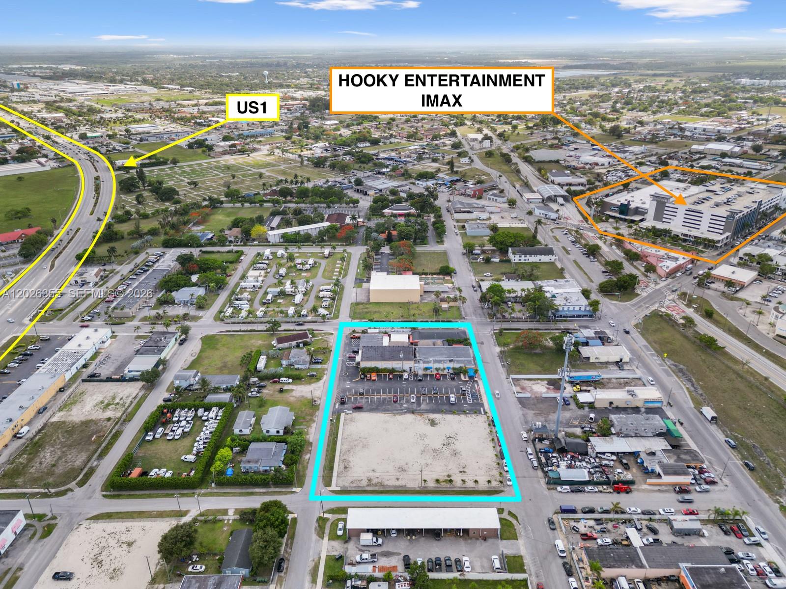 This aerial view shows a commercial property outlined in blue near a highway and cinema — 17 NE 1st Rd, Homestead FL 33030, HOMESTEAD, FL